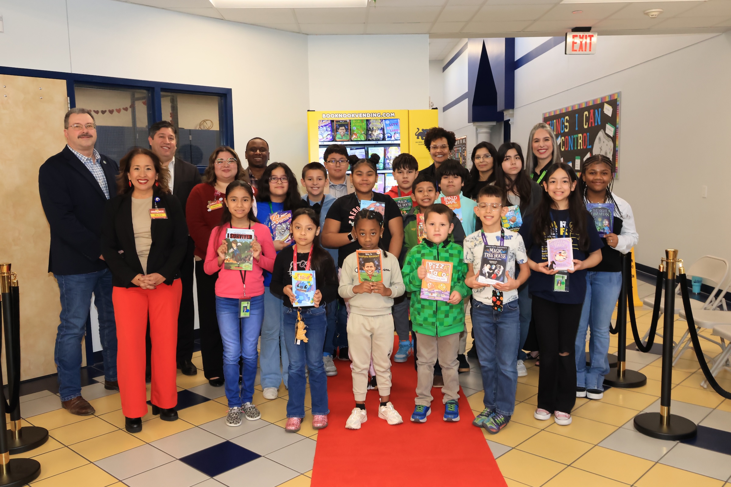 Carver elementary students, district leaders, campus leaders and community pose with book vending